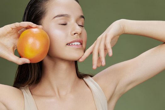 woman grapefruit in hands posing clean skin isolated background. High quality photo