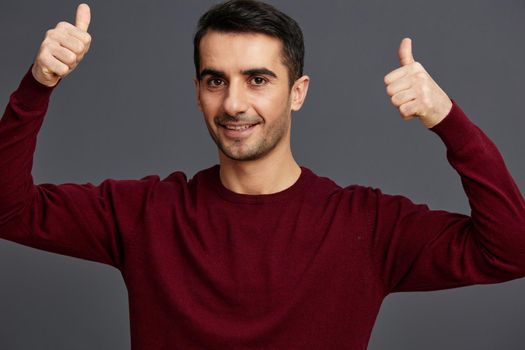 portrait man posing smile gesture hands red sweater isolated background. High quality photo