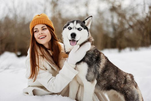 woman in the snow playing with a dog fun friendship fresh air. High quality photo