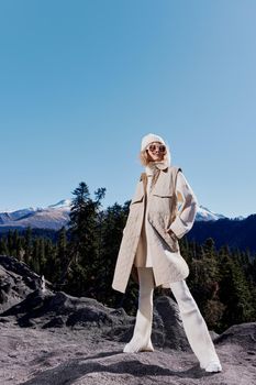 Stylish woman standing on the top of the mountain forest landscape. High quality photo