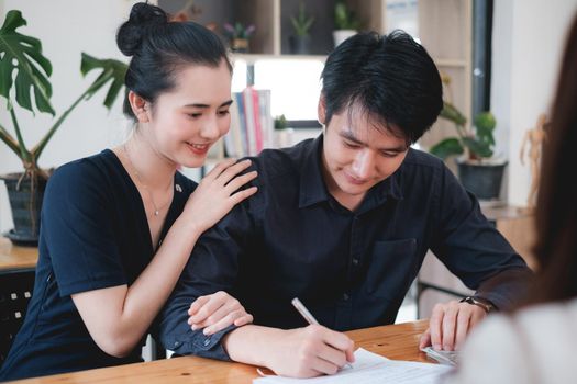 Business woman and young couple signing agreement for buying house. Bank manager and real estate concept