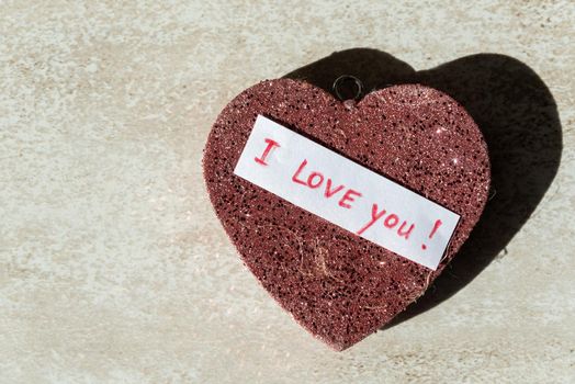 keychain in the shape of a red heart with sparkles and the inscription I love you close-up.