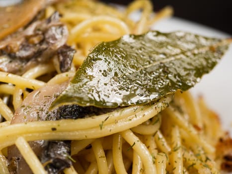 bay leaf lies on delicious italian pasta with mushrooms close up