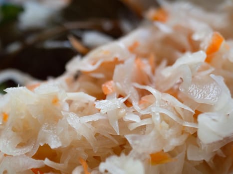 fermented cabbage with carrots. close-up. Appetizing looks. In the blur laurel.