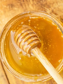 honey with wooden stirrer vertical.