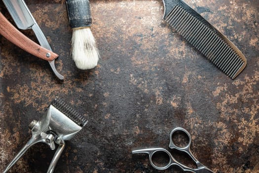 vintage barber tools dangerous razor, hairdressing scissors, old manual clipper, metal comb, shaving brush. old rusty metal background. Horizontal. top view, flat lay.