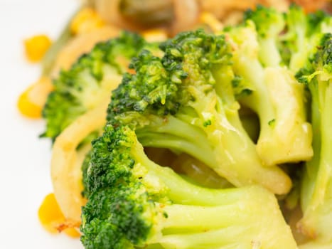 cooked vegetables broccoli, carrots, green beans, corn on a white plate. closeup