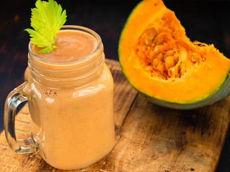 Pumpkin smoothie with celery leaves and a piece of pumpkin.