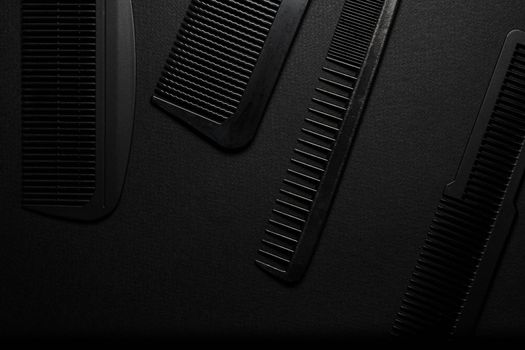 On a black surface are old barber tools. barber tools. four comb. black monochrome. frame. top view flate lay.