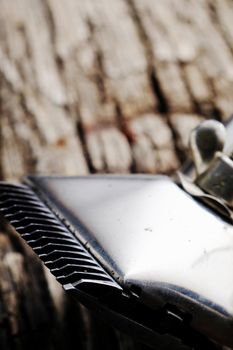 On a old wooden surface are old barber tools. Vintage manual hair clipper. vertical orientation.