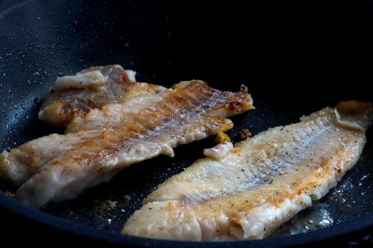 Fish is cooked in a frying pan. Fry the fish fillets. Delicious and healthy food