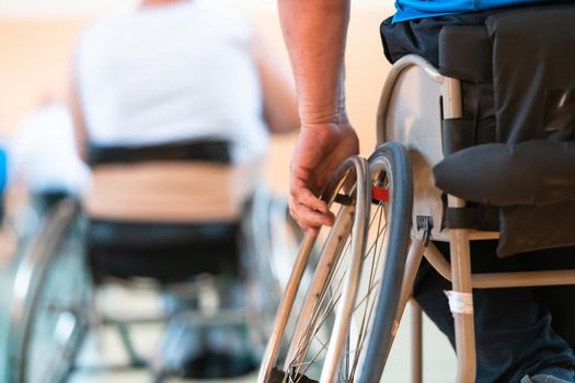 Close-up of sportsman with disability sitting in wheelchair playing basketball. High quality photo