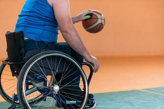 Close-up of sportsman with disability sitting in wheelchair playing basketball. High quality photo