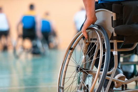 Close-up of sportsman with disability sitting in wheelchair playing basketball. High quality photo