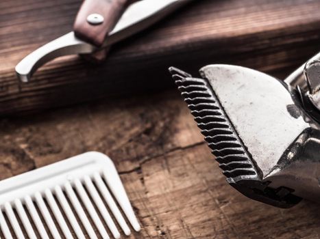 barber tools. vintage clipper straight razor hair brush. wooden background.