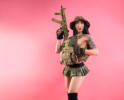 the sexy brunette girl in military clothes and body armor with weapons