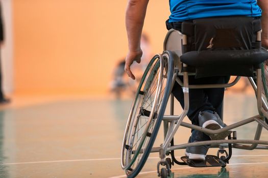 Close-up of sportsman with disability sitting in wheelchair playing basketball. High quality photo
