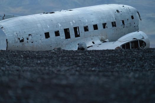 Wreck of and airplane profile over the dark black sand