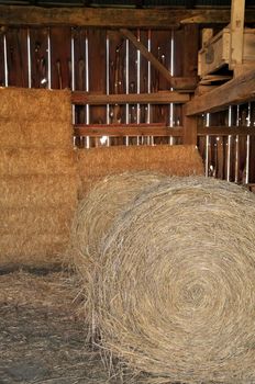 Close up of Round and Square Hay Bales in an old wooden Barn. High quality photo