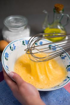 detail whisk eggs in a white bowl with a whisk. High quality photo