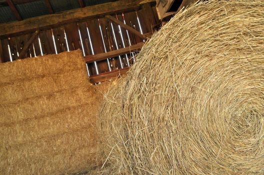 Close up of Round and Square Hay Bales in an old wooden Barn. High quality photo
