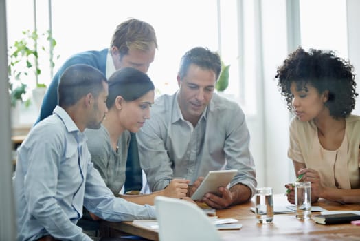 Shot of a group of professionals using wireless technology during a meeting