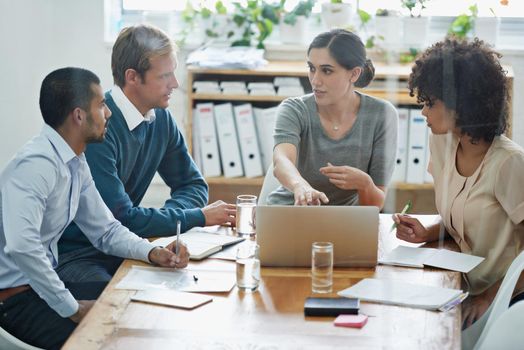 Shot of a group of professionals using wireless technology during a meeting