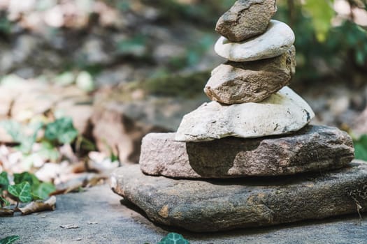 zen stone stack with balanced stones on stones in equilibrium, pile of rocks in the woods. horizontal