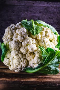 Fresh Raw organic ugly cauliflower on old wooden background . Vegetarian recipe or menu background. Vertical orientation.