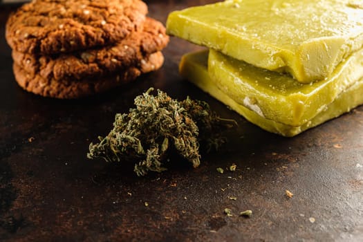 biscuits with marijuana and cannabis butter and bud on an old wooden background close-up. Healthy medical food with cannabis. the buds are inaccurately scattered. rustic. Horizontal orientation.