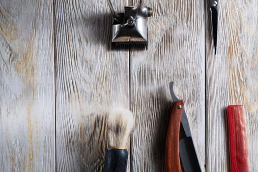 barber tools. hairdressing scissors vintage manual clipper comb brush dangerous razor are on a white weathered wooden surface. copy space. Horizontal orientation. Close-up. flat lay. top view