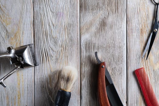 barber tools. hairdressing scissors vintage manual clipper comb brush dangerous razor are on a white weathered wooden surface. copy space. Horizontal orientation. Close-up. flat lay. top view