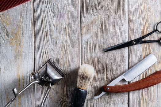 barber tools. hairdressing scissors vintage manual clipper comb brush dangerous razor are on a white weathered wooden surface. copy space. Horizontal orientation. Close-up. flat lay. top view