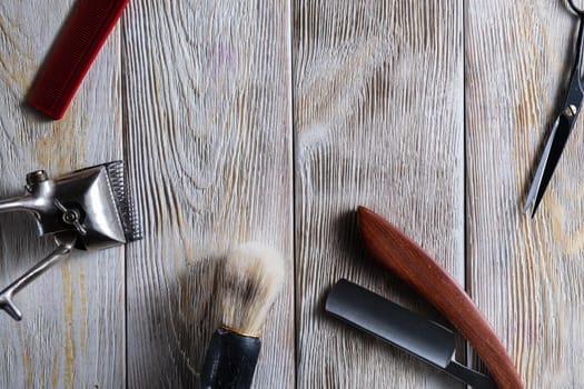 barber tools. hairdressing scissors vintage manual clipper comb brush dangerous razor are on a white weathered wooden surface. copy space. Horizontal orientation. Close-up. flat lay. top view