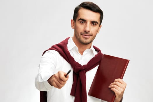 handsome man in a white shirt sweater on the shoulders notebook posing business and office concept. High quality photo