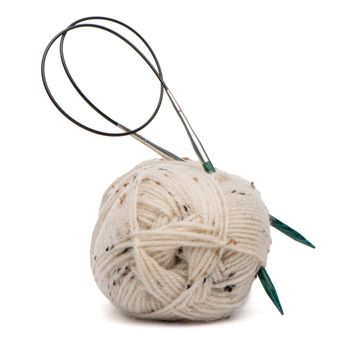 Beige knitting wool or yarn with knitting needles.