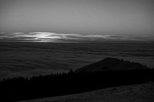 the romance of tourism and recreation, as well as the principles of a healthy lifestyle, is to watch the fantastic play of the sun's rays setting over the horizon on the highest Wasserkuppe mountain in Hesse, Germany and breathe fresh clean mountain air black and white photo High quality photo