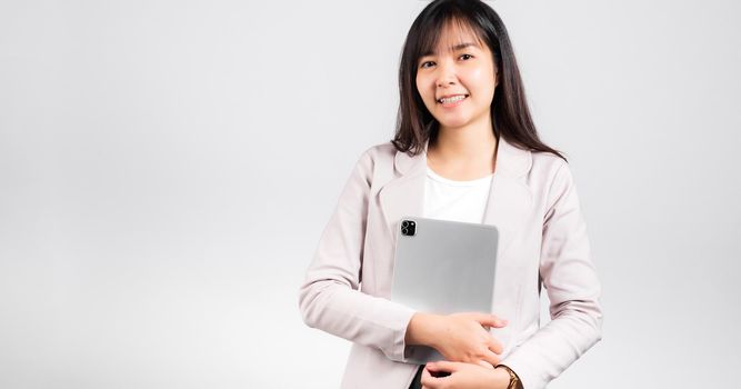Portrait of Asian beautiful young woman smiling holding tablet computer, Happy lifestyle female teen hugging digital tablet pc, studio shot isolated on white background, university e-book equipment