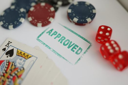 Imprint approved among cards, dice and casino chips, close-up. Legal gambling, club gaming equipment