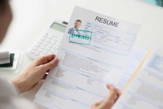 The recruiter holds a man's resume in his hands, close-up. Candidacy approved, recruitment agency, staff selection