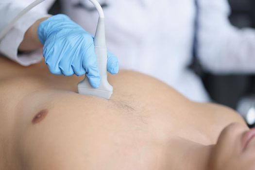 Doctor's hands on the chest of a man, ultrasound of the heart, close-up. Diagnosis of diseases of the cardiovascular system