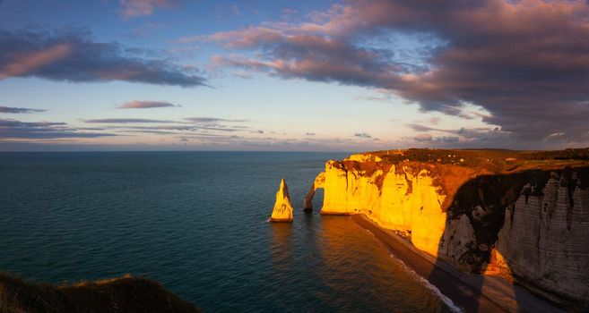 Amazing sunset on the coast in Etretat. Panorama picture. Etretat is a charming town famous for the stunning cliffs of Etretat on the Alabaster Coast and one of Normandys most popular tourist sites.
