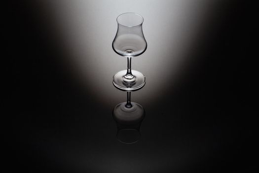 Rum tasting glass on the glass table and black background