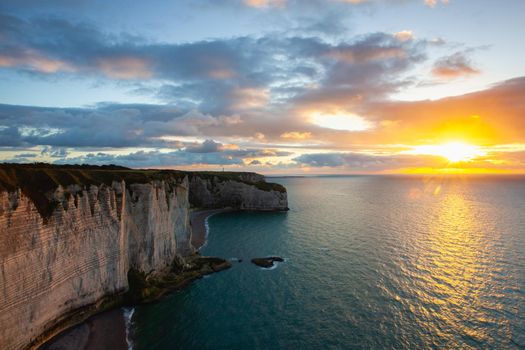 Dramatic sunset on the coast in Etretat, France. Etretat is a charming town famous for the stunning cliffs of Etretat on the Alabaster Coast and one of Normandys most popular tourist sites.