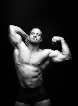 sports man standing on a black background, doing sports