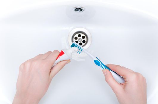brushing your teeth in the sink with a toothbrush