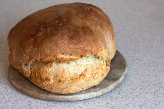 home made fresh bread with crispy crust is on a kitchen board