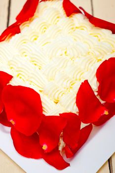 whipped cream mango cake with red rose petals 