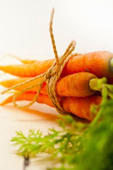 fresh baby carrots bunch tied with rope on a rustic table