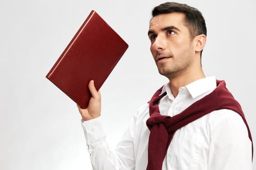 man in a white shirt sweater on the shoulders notebook posing isolated background. High quality photo